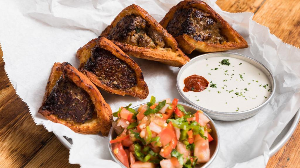 Arayes · Grilled pita filled with minced lamb, served with a spicy cherry tomato salad and tahini.