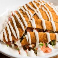 Schnitzel Salad · Breaded chicken breast over Israeli salad, topped with tahini.