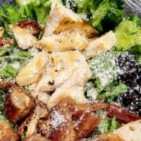 Chicken Caesar Salad · Chopped romaine topped with grilled chicken, crumbled bacon, cucumbers, black olives, Parmes...