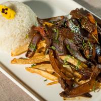 Lomo Saltado · Pepper steak sautéed with onions and tomatoes. Served with rice and french fries.