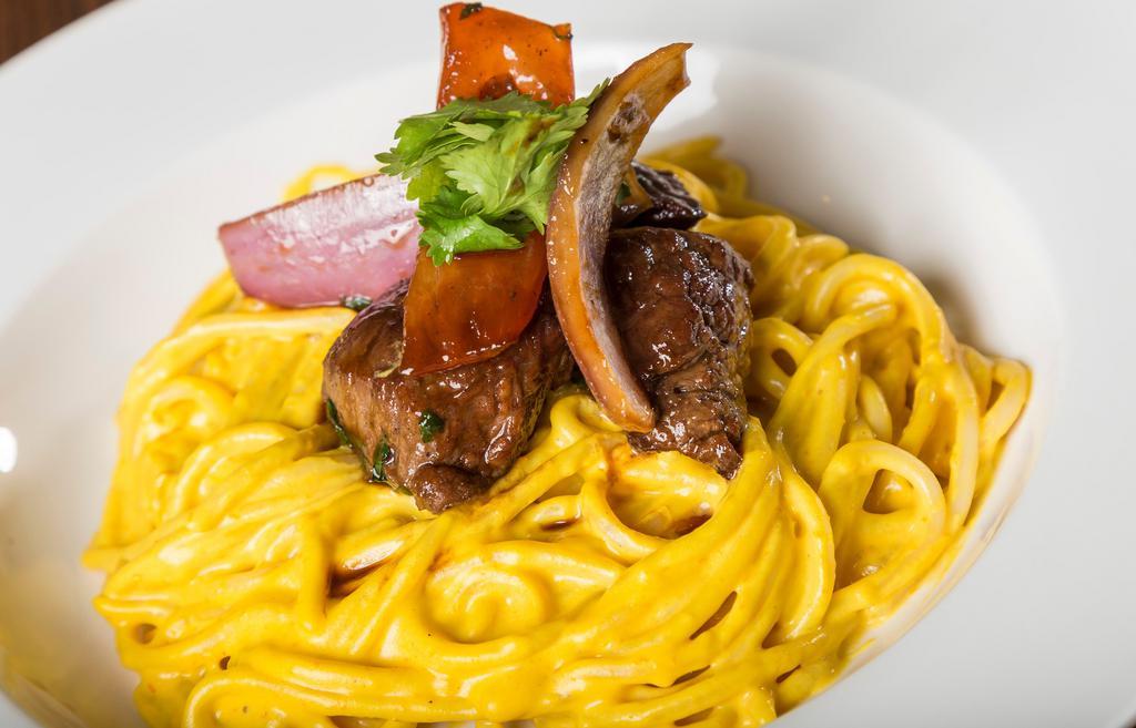 Tallarin A La Huancaina Con Lomito Saltado · Spaghetti in yellow Peruvian pepper sauce with pepper steak, onions tomatoes in oyster sauce and soy sauce.