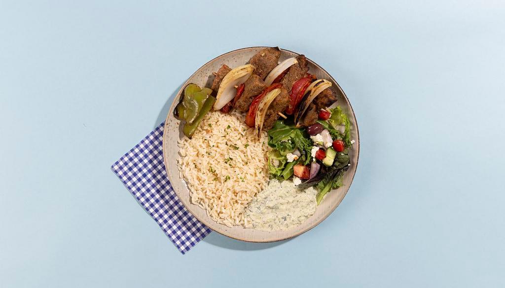 Lamb Skewer Rice Platter · Grilled lamb skewers served with rice, salad, pita bread, and tzatziki.