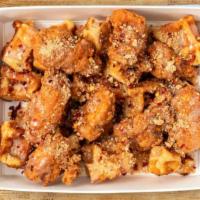 Chicken & Waffles · Waffle sauce, graham crackers, and crushed red pepper flakes over a mix of chicken poppers a...