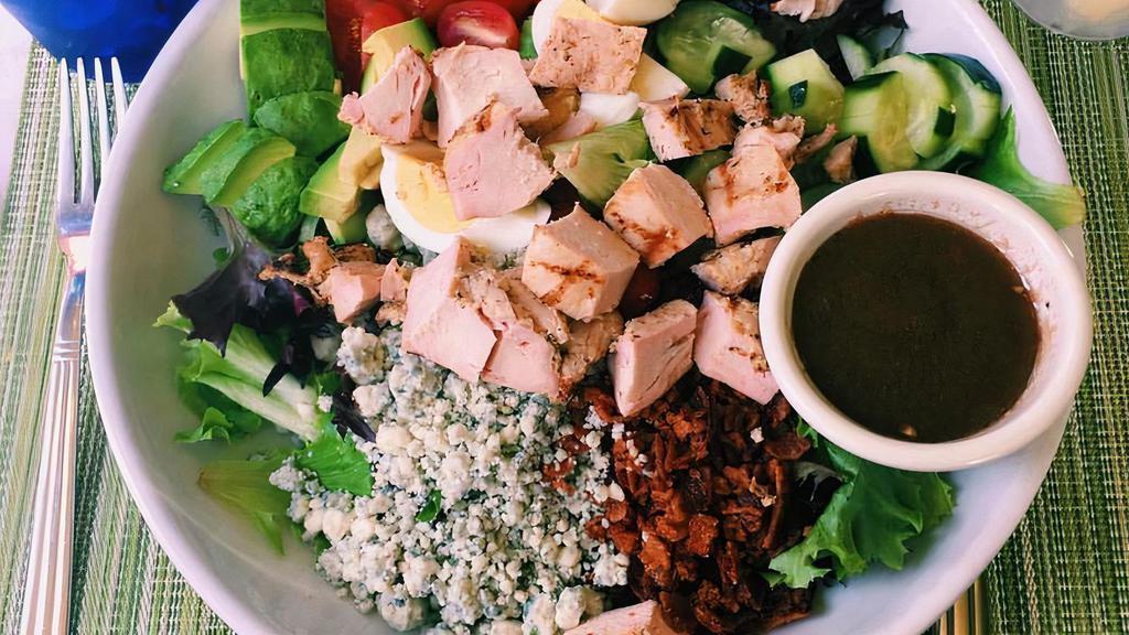 Cobb Salad · Grilled chicken, avocado, blue cheese, applewood smoked bacon, hard-boiled egg, tomato, cucumber, red onion, and mixed greens.