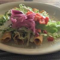 Lunch Flautas Pollo · Two deep fried corn tortillas filled with chicken then topped with cheese sauce. Served with...