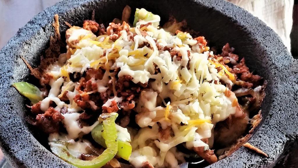 Molcajete Original · Grilled steak, chicken and shrimp cooked with vegetables then topped with chorizo and cheese.