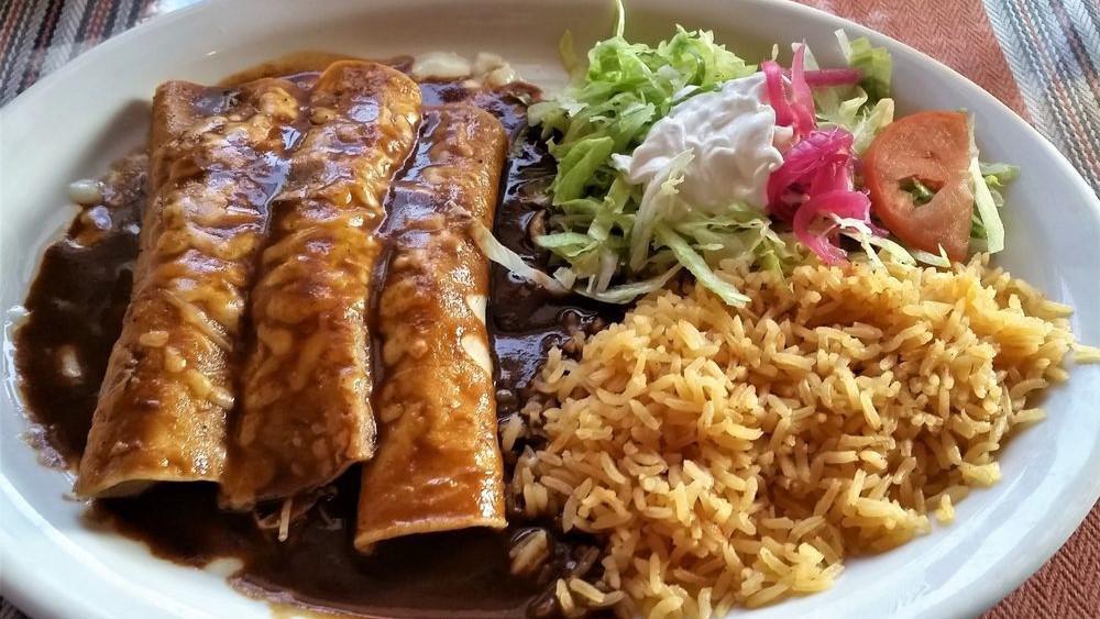 Mole Enchiladas · Three chicken enchiladas. Topped with our homemade mole sauce. Served with rice, lettuce, tomatoes and sour cream.