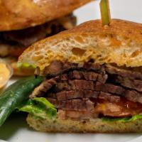 Brisket Sandwich · House smoked brisket with lettuce and tomato. Served on ciabatta bread, with a pickle & Russ...