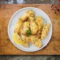 Garlic Manic Wings · Fresh chicken wings breaded, fried until golden brown, and tossed in garlic. Served with a s...