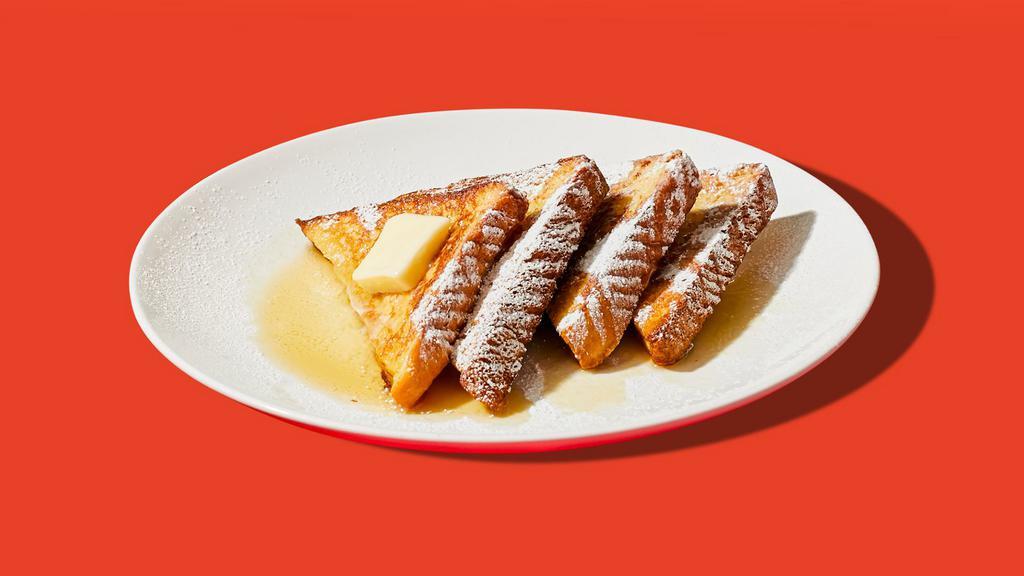 Classic French Toast · Four slices of egg-washed french toast topped with maple syrup and butter.