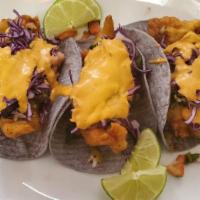 Baja-Style Fish Tacos · Beer-battered fish topped with cilantro, onions, pico de gallo, red cabbage and chipotle aio...