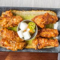 Korean Fried Chicken (6 Pcs.) · Chicken wings glazed with soy garlic sauce or spicy gochujang sauce. Served with pickled jal...