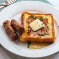 Sausage French Toast With Syrup · Fresh fluffy French toast topped with slices of sausage and syrup.