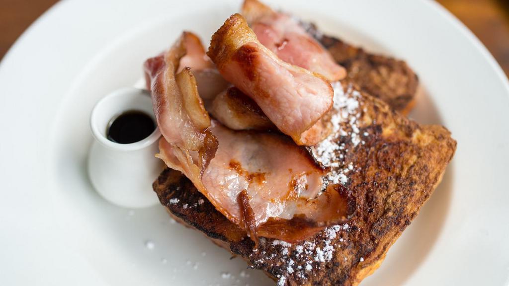 Ham French Toast With Syrup · Fresh fluffy French toast topped with slices of ham and syrup.