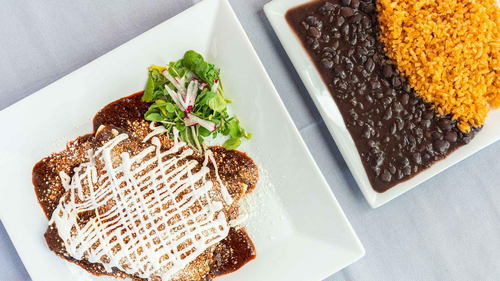 Enchiladas De Mole · Three chicken enchiladas topped with mole sauce, cheese, and sour cream. Served with rice and beans.