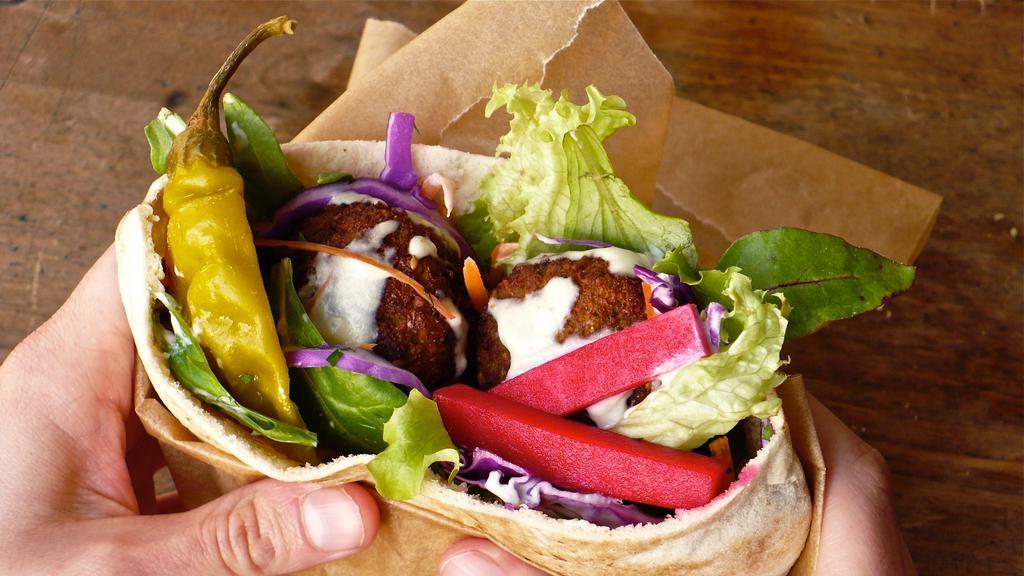 Classic Falafel · Finely ground chickpeas, onions, parsley, garlic, spices, lettuce, tomatoes, onions, and tahini sauce.