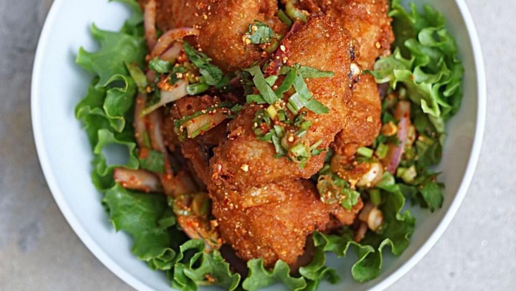 Wing Zabb · Spicy**, Deep-fried chicken wings tossed with chili, rice powder, red onion, scallion and cilantro.