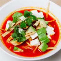 Sopa De Tortilla · Light tomato, chile guajillo soup, crispy tortilla strips, Mexican cheese, and avocado.