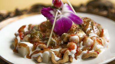 Lachha Papri Chatt · Potato spirals topped with crisp papri, masala yogurt infused with mint and tamarind chutney.