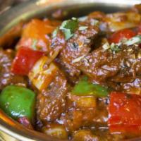 Lamb Kadhai · Cooked lamb braised in a masala of coarse ground spices with sautéed onions and bell peppers.
