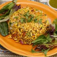 Bhel Poori · A crispy cool mix of puffed rice, diced potatoes, onions, crisp crackers, herbs, and chutneys.