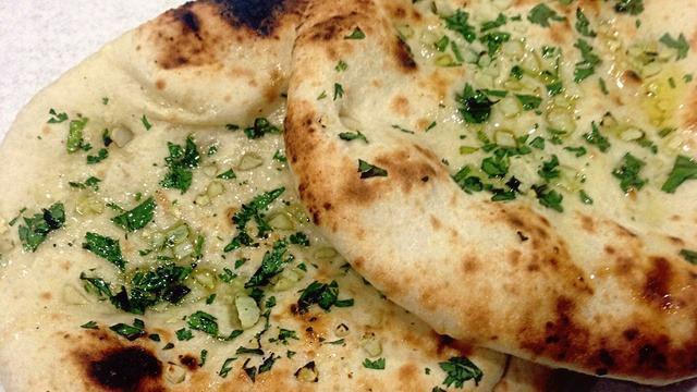 Garlic Naan · Tandoor-baked flatbread seasoned with garlic.