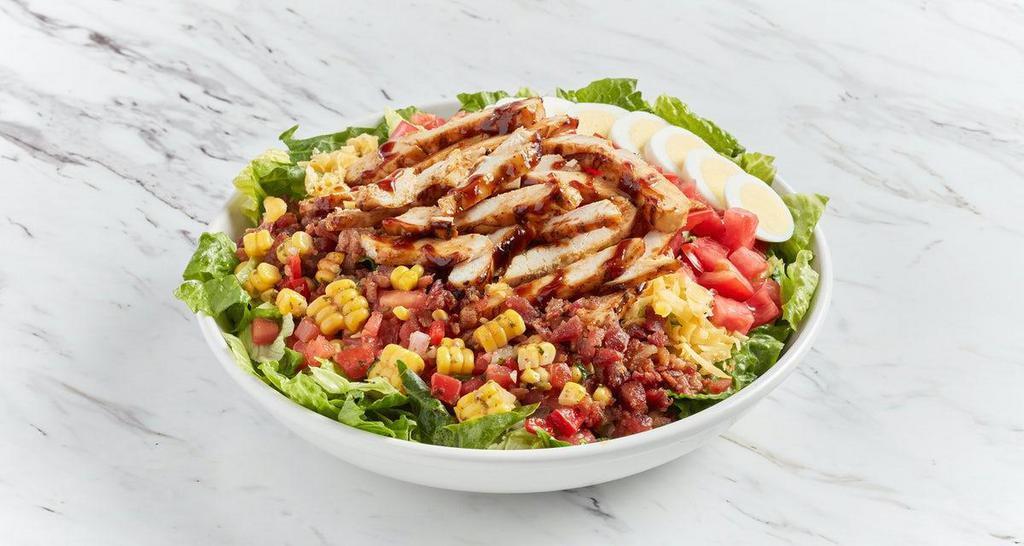 Bbq Chicken Cobb Salad · Romaine and iceberg lettuce topped with chopped BBQ grilled chicken, charred corn salsa, smoked cheddar, tomatoes, sliced egg, applewood-smoked bacon.  Served with roasted garlic ranch dressing on the side.