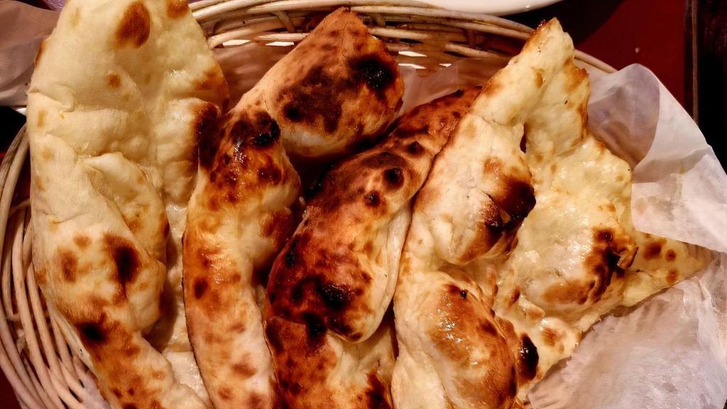 Garlic Naan · Silky unleavened bread cooked in a clay oven.