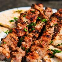 Pork Souvlaki · Greek traditional pita served with red onion, tomato, lettuce, french fries wrapped in warm ...