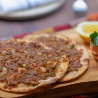 Findik Lahmacun · Round flatbread with minced meat, sumac, onion, parsley, and tomato.