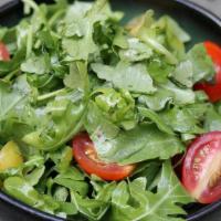 Green Salad · Arugula and cherry tomatoes dressed with lemon olive oil dressing.