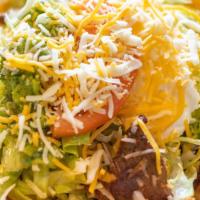 Taco Salad · Fried tortilla shell filled with ground beef or chicken, beans and cheese sauce, topped with...