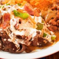 Alambre · Grilled chops tender steak accompanied with grilled onions, green peppers, and bacon topped ...