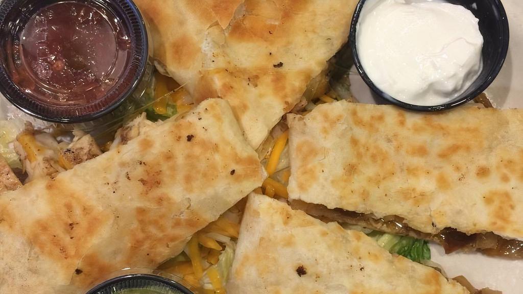 Chicken Quesadilla · Chicken breast, fried onions and melted cheddar Cheese, served With sour cream.