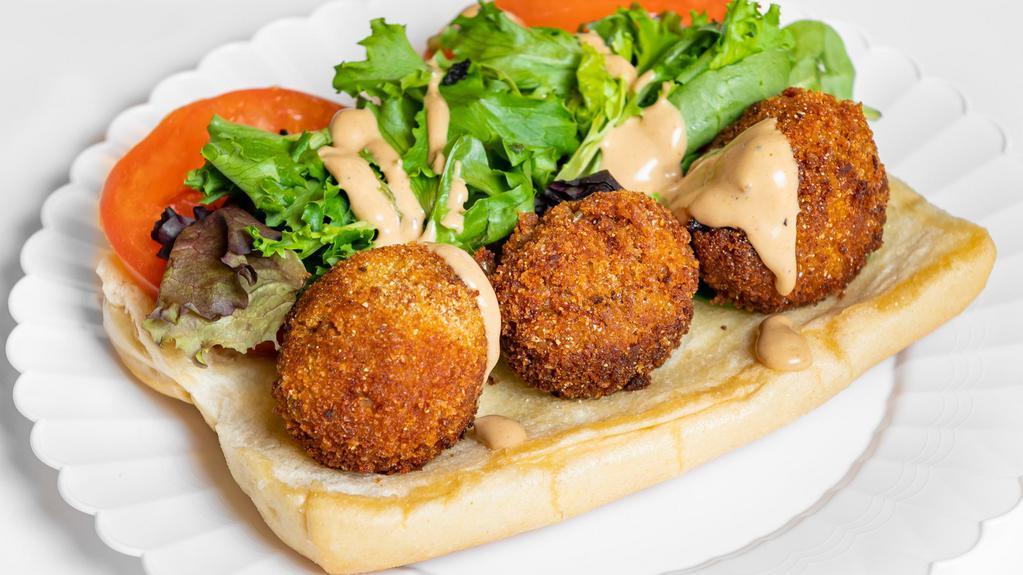 Vegan Po’ Boy Sandwich · Vegan Hand Crafted Tuna Balls on a Fresh Roll with Coleslaw, Tomato and Butter Pickles with a Drizzle of Remoulade Sauce.