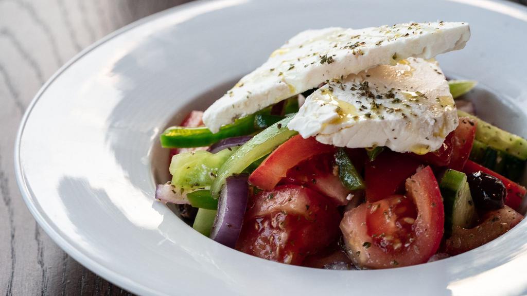 Horiatiki · Vegetarian. Classic Greek salad, vine-ripened tomatoes, cucumbers, red onions, olives, peppers, arachova's Feta cheese, oregano, aged balsamic, and evoo.