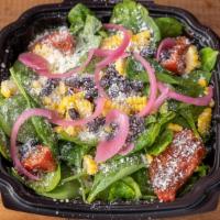 Mexican Street Corn Salad · Baby spinach, smoked tomatoes, roasted corn, red onion, cotija cheese, black beans and dress...