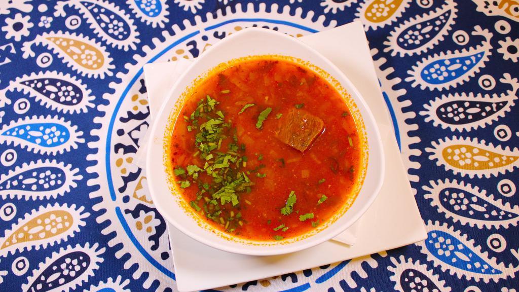 Kharcho · Beef, rice in tomato broth w/spices and fresh herbs.