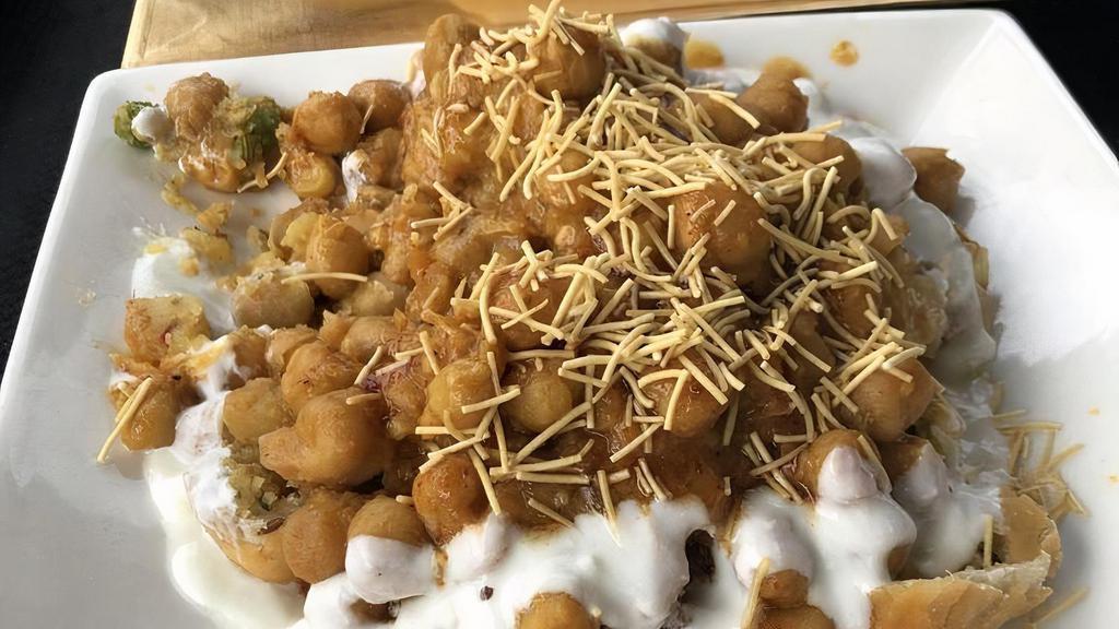 Papdi Chaat · A combination of crispy chips, chanay, onions and herbs seasoned in spicy yogurt, mint chutney and tamarind chutney, covered with sev (thin noodles).