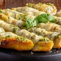 Cheesy Pesto Garlic Bread · Uno’s pizza dough topped with basil pesto, fresh garlic and Uno’s three-cheese blend of fres...