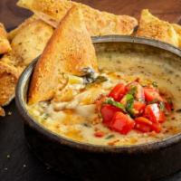Spinach & Artichoke Dip · A housemade blend of creamy spinach and artichokes served hot with crispy tortilla chips.