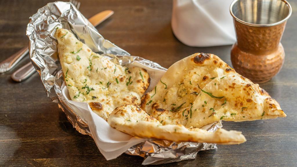 Garlic Naan · Naan stuffed with seasoned onion and baked in a traditional clay oven.