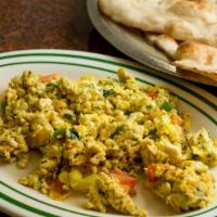 Shak-Shookah · Scrambled eggs with sautéed tomatoes, onion and parsley served with warm clay oven bread.