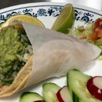 Single Taco Soft Corn Tortilla · Served with guacamole, cilantro and onions.