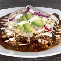 Enchiladas Poblanas · Three soft corn tortillas, topped with mole poblano, sour cream, cotija cheese, lettuce, oni...