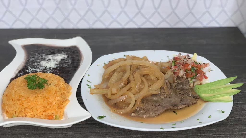 Bistec Encebollado · Mexican-style steak and onions, marinated in olive oil, various spices. Served with rice and beans.