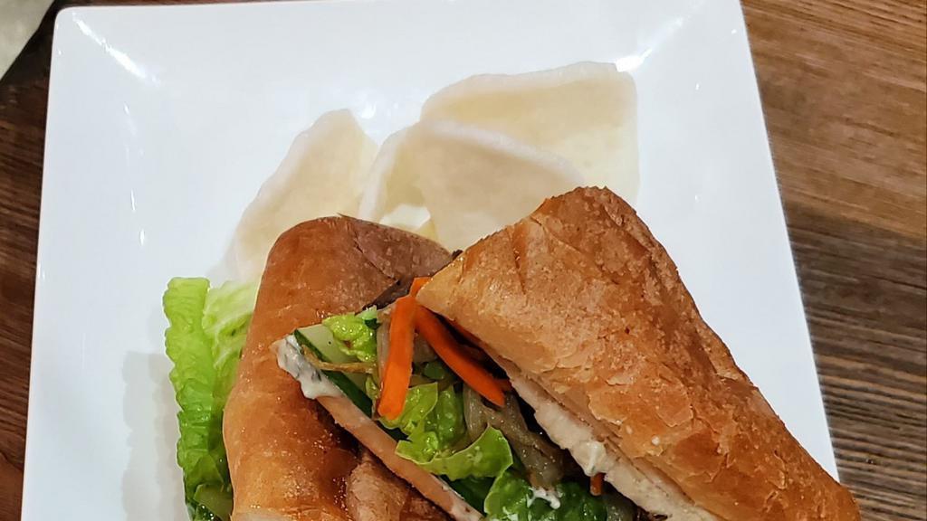 Viet Steak Sandwich · Five-spice marinated flank steak, sauteed sweet onions, cilantro cream, on toasted baguette with fresh herbs, vegetables, side of shrimp chips and hot sauce