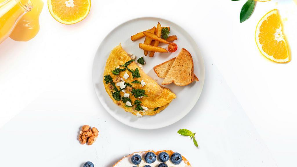 Greek Omelette · Eggs cooked with olives, feta cheese, and cherry tomato as an omelette and served with toast and home fries.