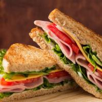 Turkey Club Sandwich · Sandwich with oven gold turkey, beef bacon, Swiss cheese, lettuce, and tomato topped with Ru...