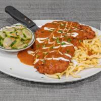 Hungarian Schnitzel · Breaded and fried pork cutlet covered in hungarian paprika sauce served with spaetzle and cu...